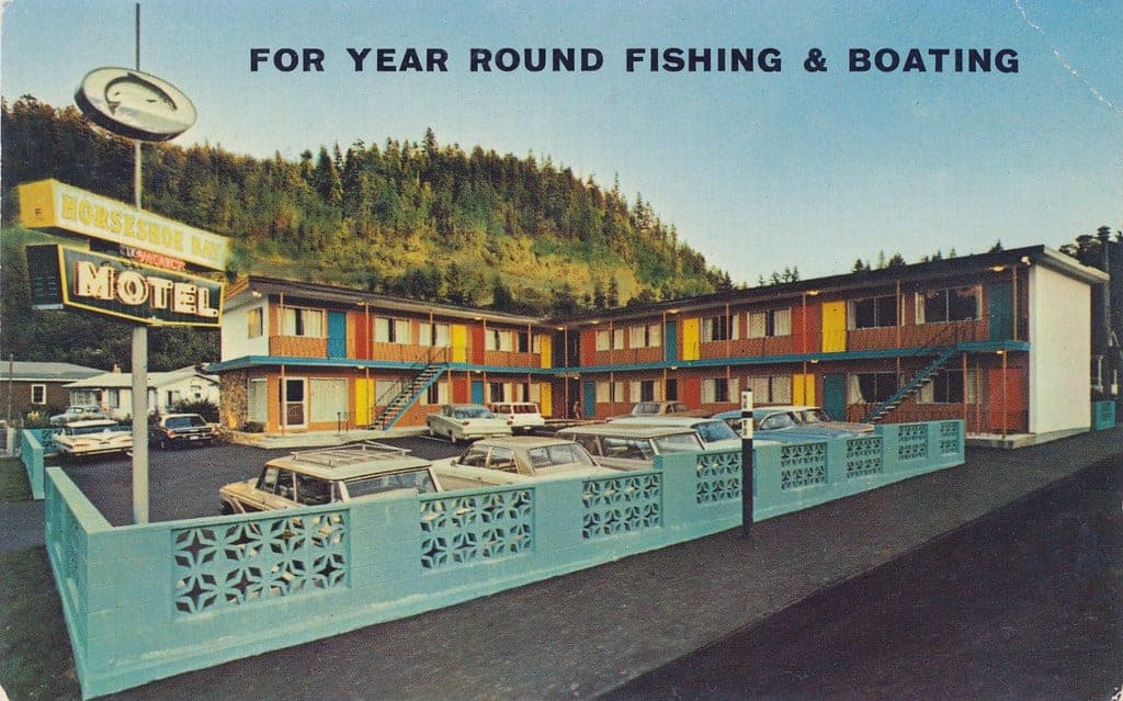 Postcard view of Horseshoe Bay Motel in 1963 with its coloured doors facing the forested hillside.