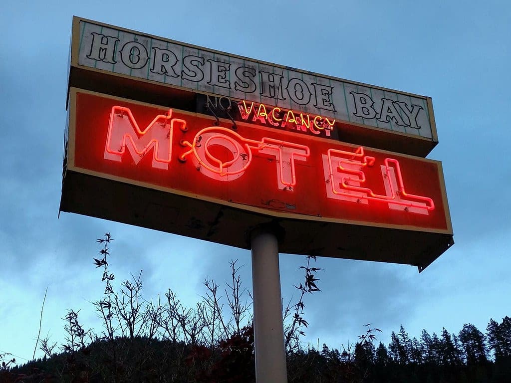 Horseshoe Bay Motel's red neon sign lit against the evening sky.