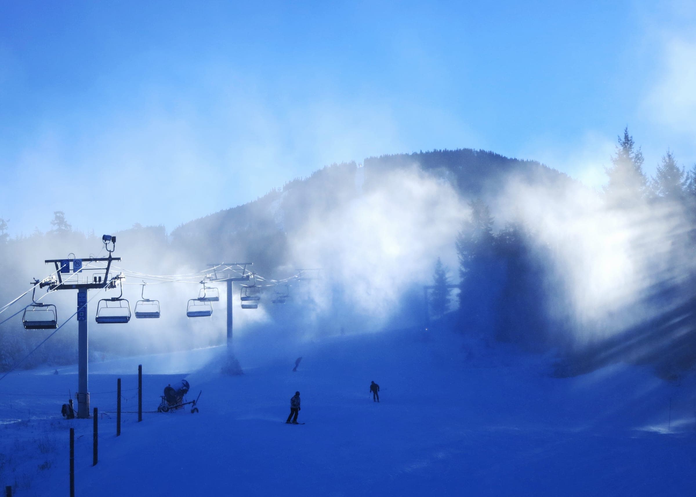 Snow guns blow over the lowest run of Whistler Mountain above Skier's Plaza on a November morning.