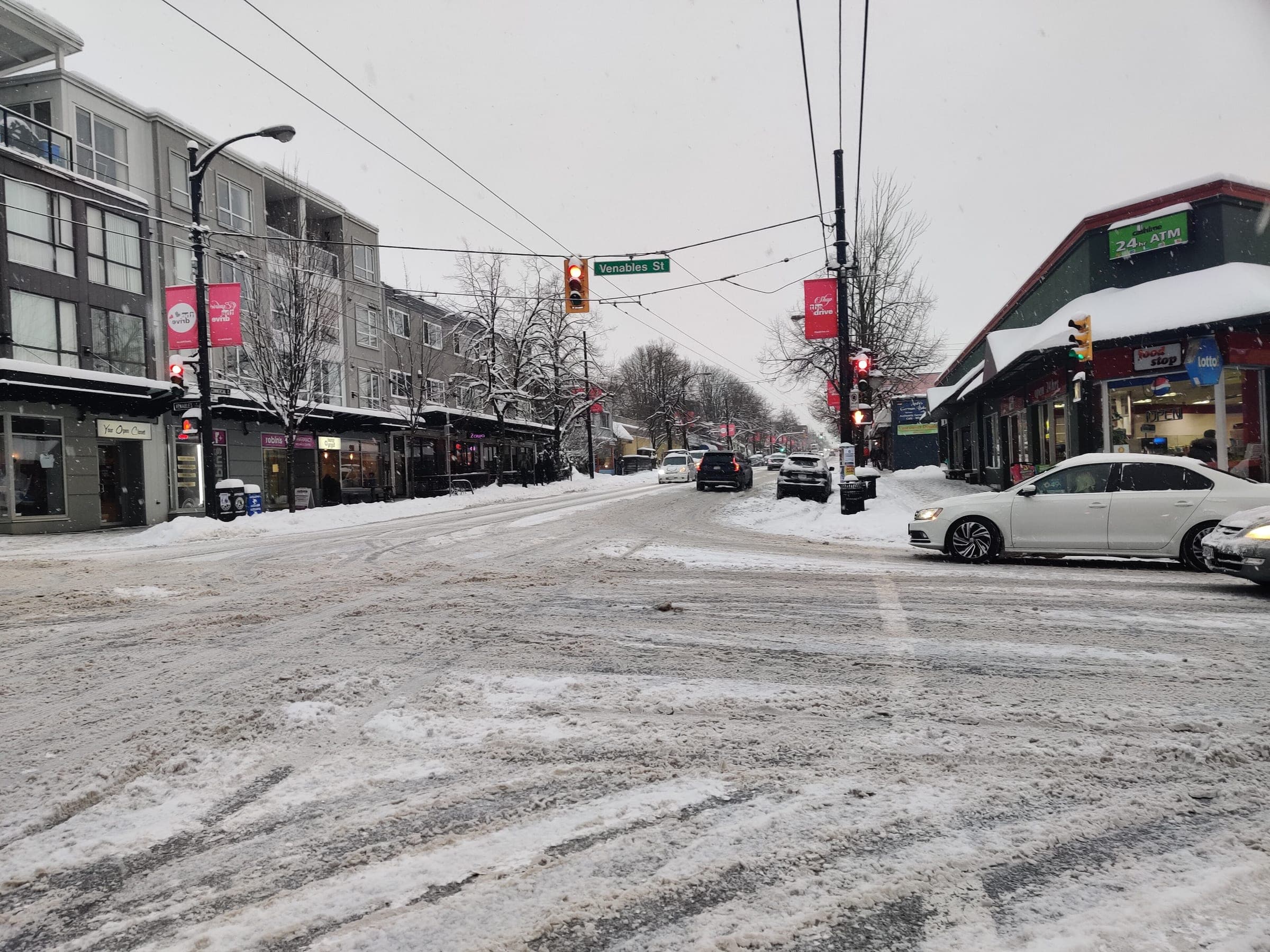 Packed snow covers Commercial Drive and the rooftops of its corner shops after a January storm.