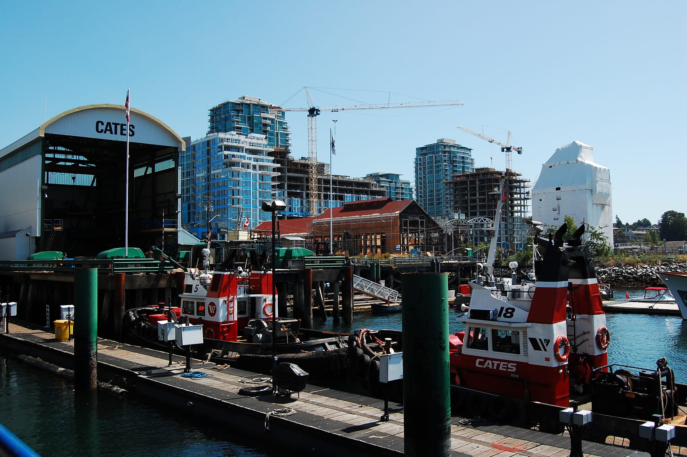 Red Cates tugboats tie up at the Lower Lonsdale docks below new towers and the old Shipyards buildings.