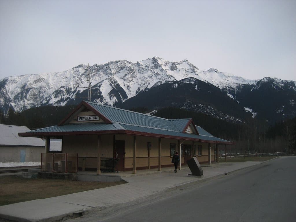 The old Pemberton railway station sits below the snowy summit of Mount Currie on a spring evening.