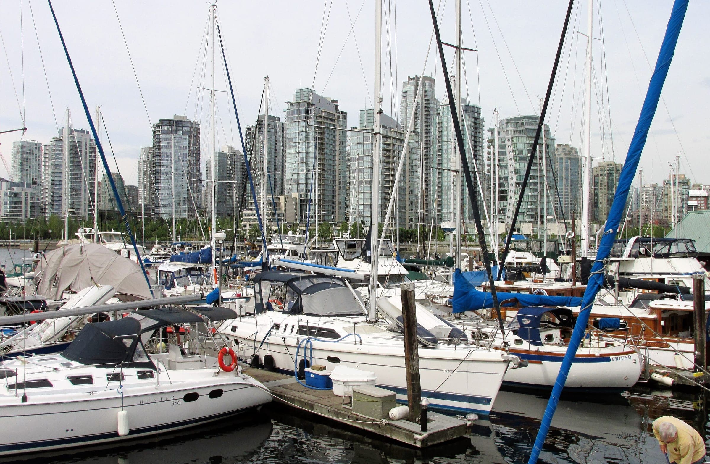 Sailboats crowd Spruce Harbour Marina on False Creek with the Yaletown towers rising beyond the masts.