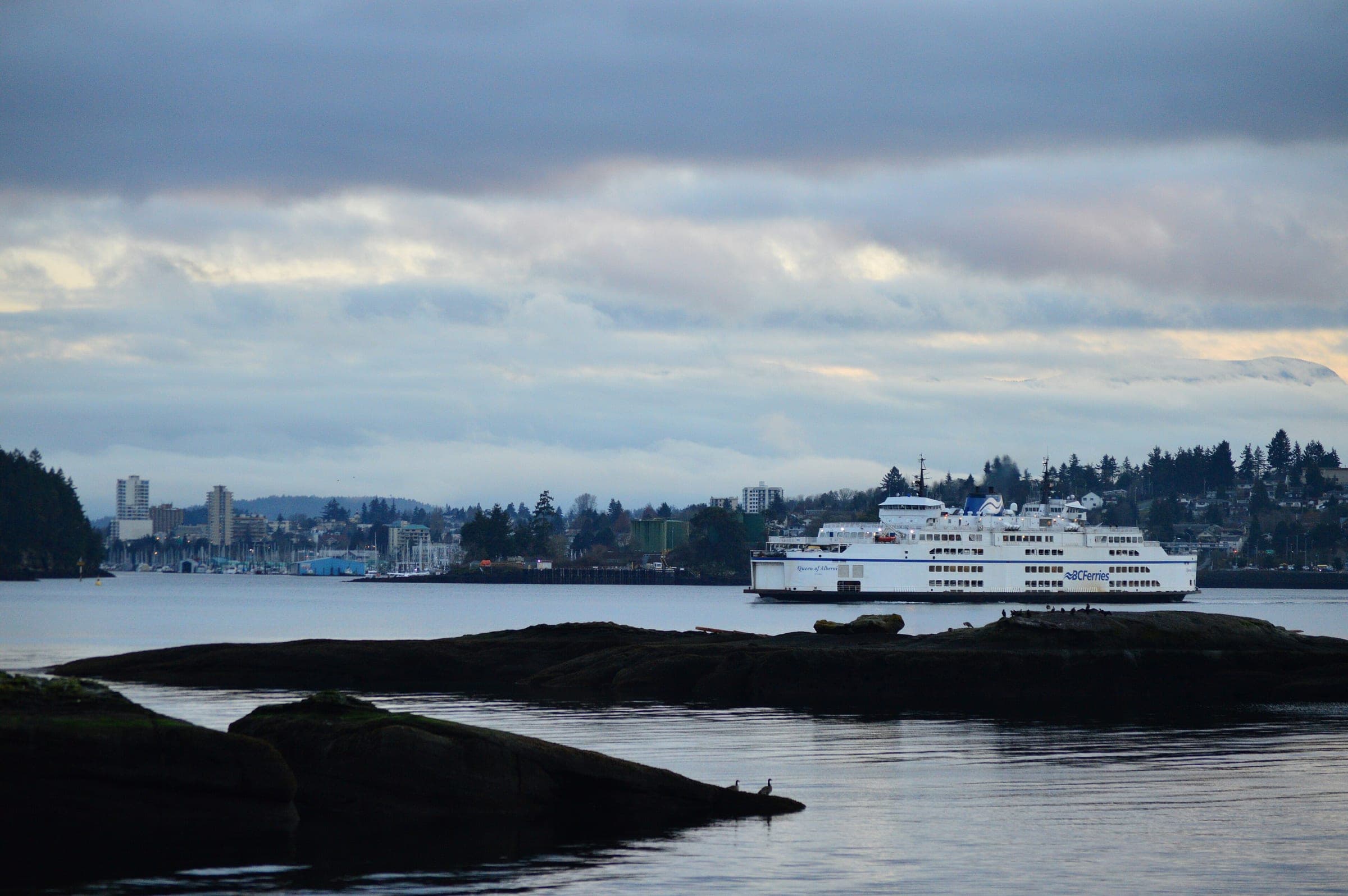 The BC Ferries vessel Queen of Alberni crosses the water off Nanaimo under evening cloud.