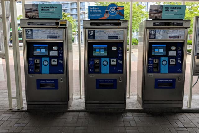 Three Compass vending machines stand in a row at King George SkyTrain station.