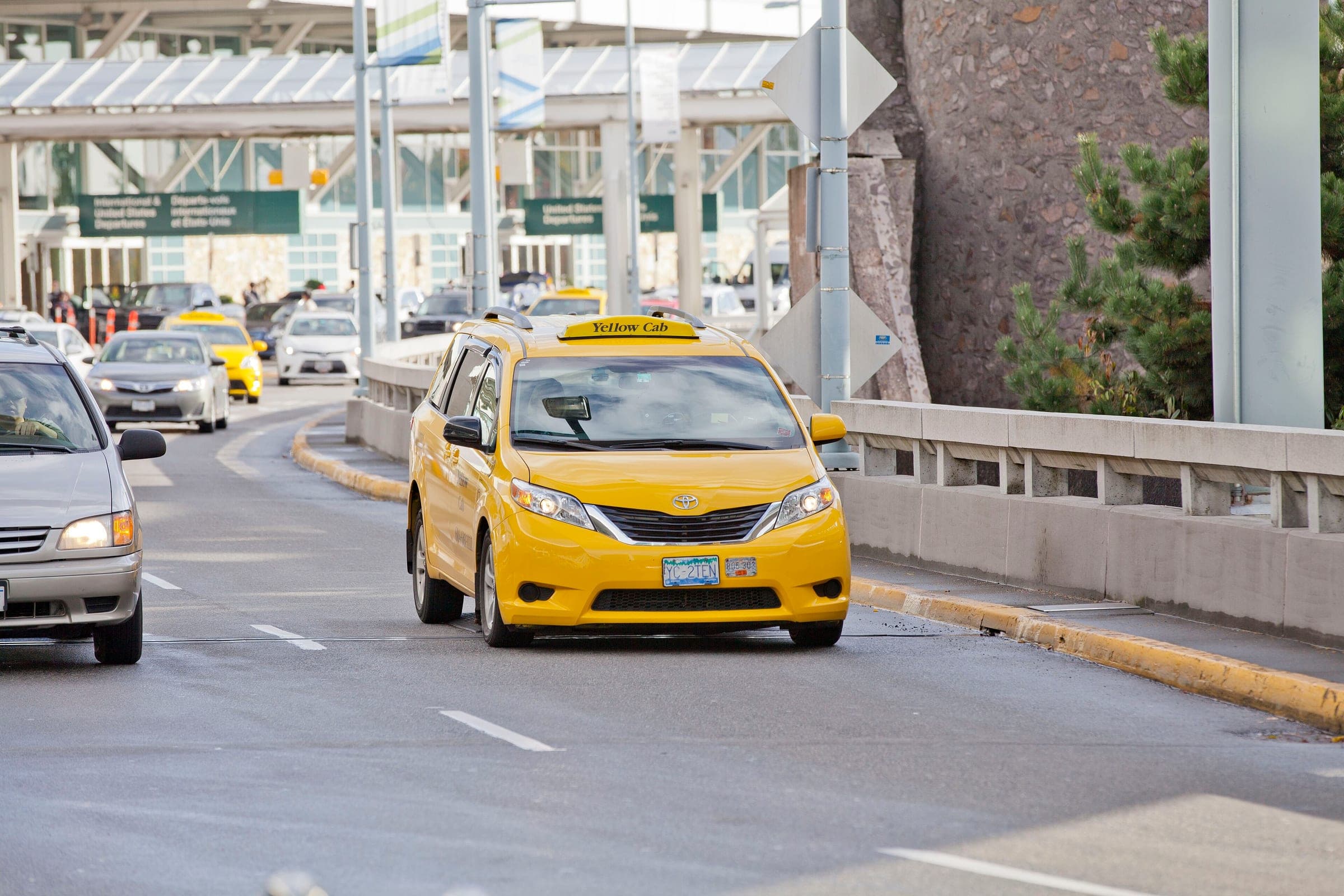 A yellow taxi leaves the pickup lanes at Vancouver International Airport.