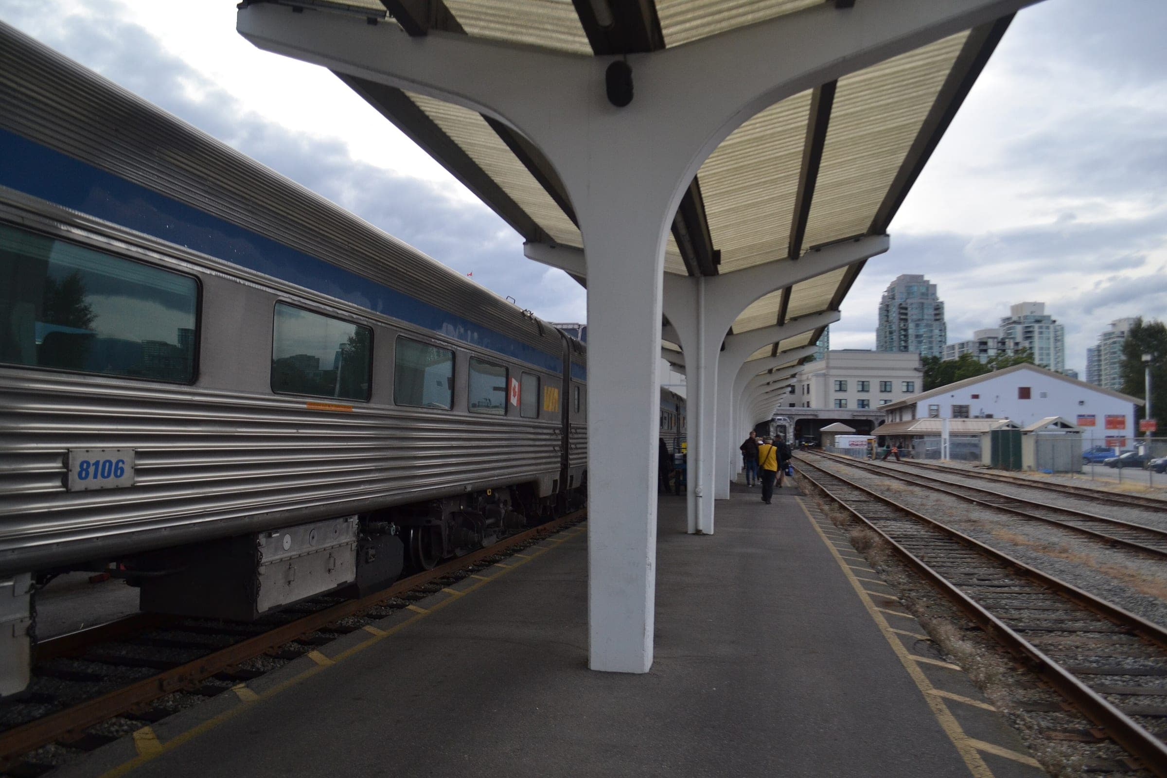 A VIA Rail train stands under the canopy at the Pacific Central Station platform in Vancouver.